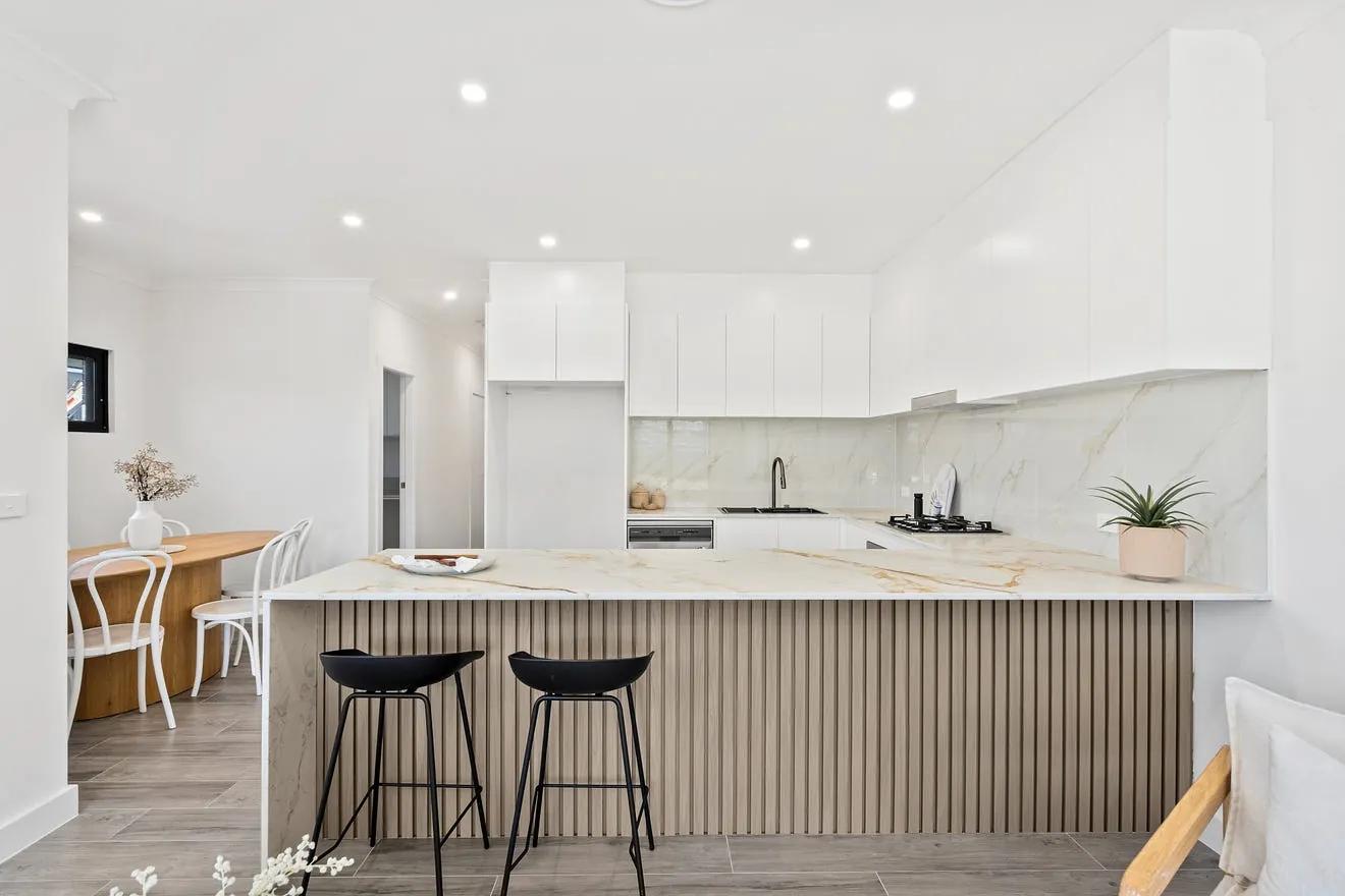 Kitchen with a timber island by Ovas Build
